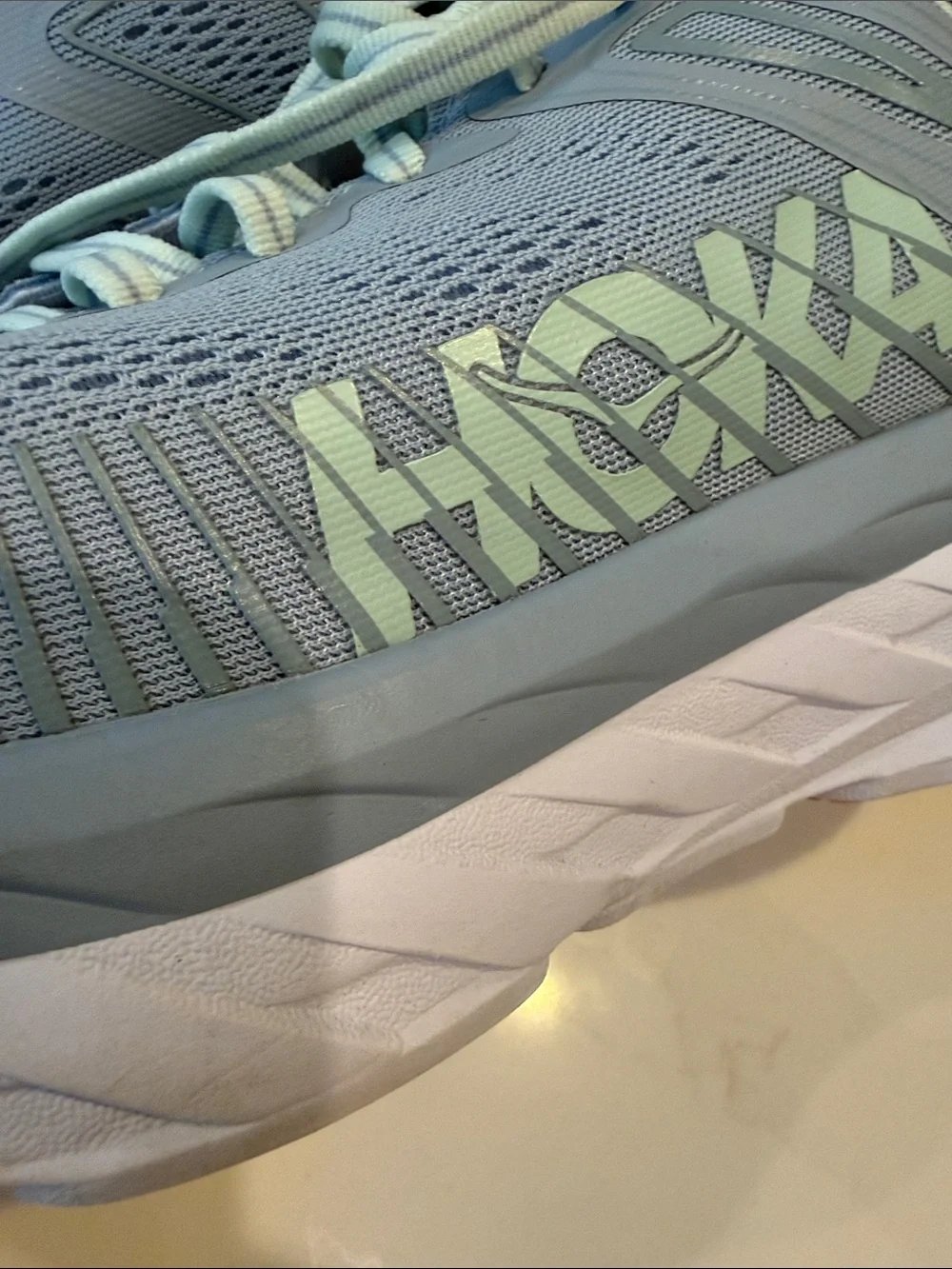 Hoka Pale Gray Running Shoes with orange Accents